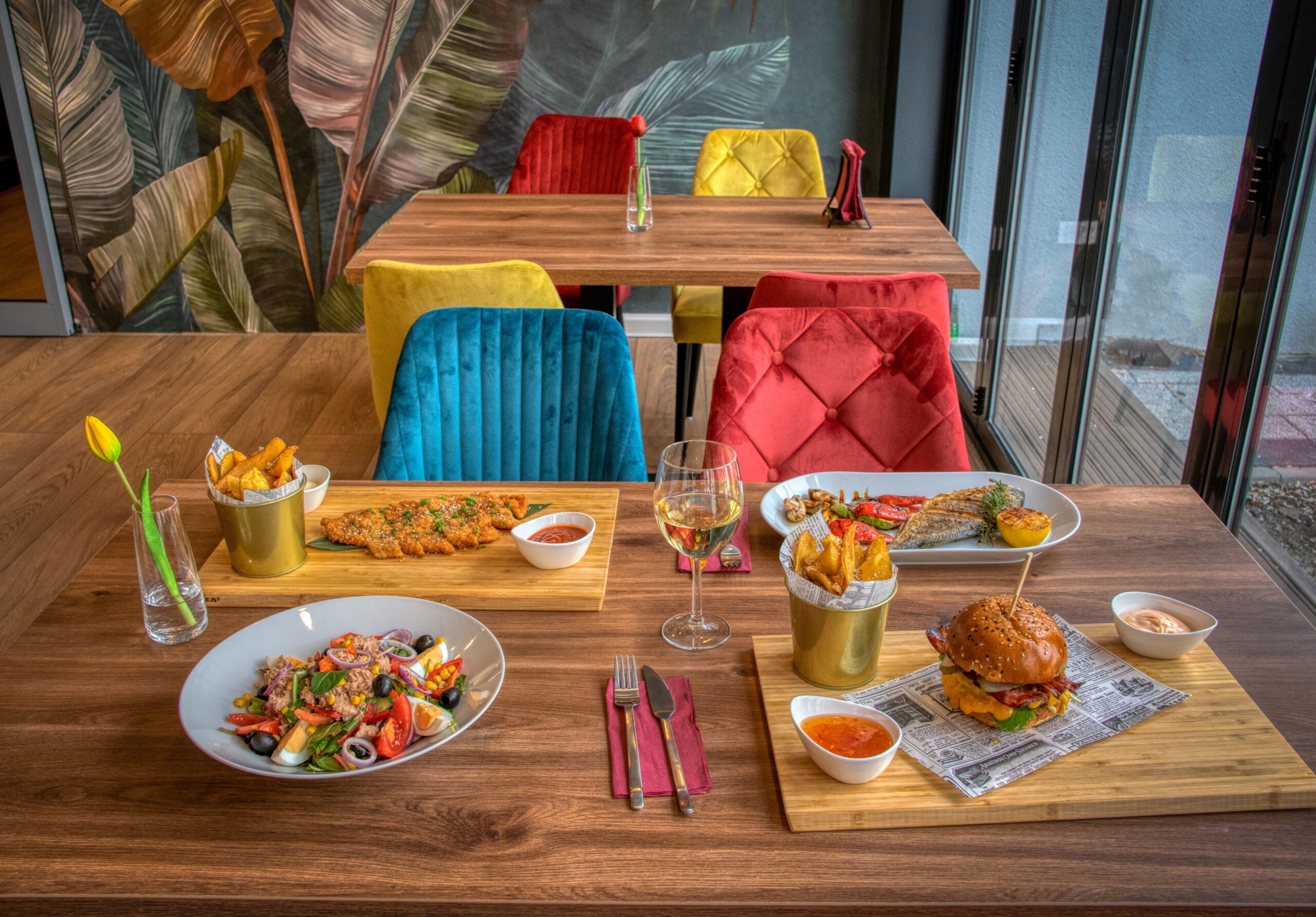 Colorful dining setup in a modern restaurant featuring diverse meals and vivid decor.