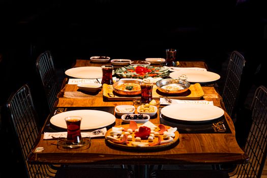 An inviting Mediterranean dining table with appetizers and traditional decor, perfect for group meals.