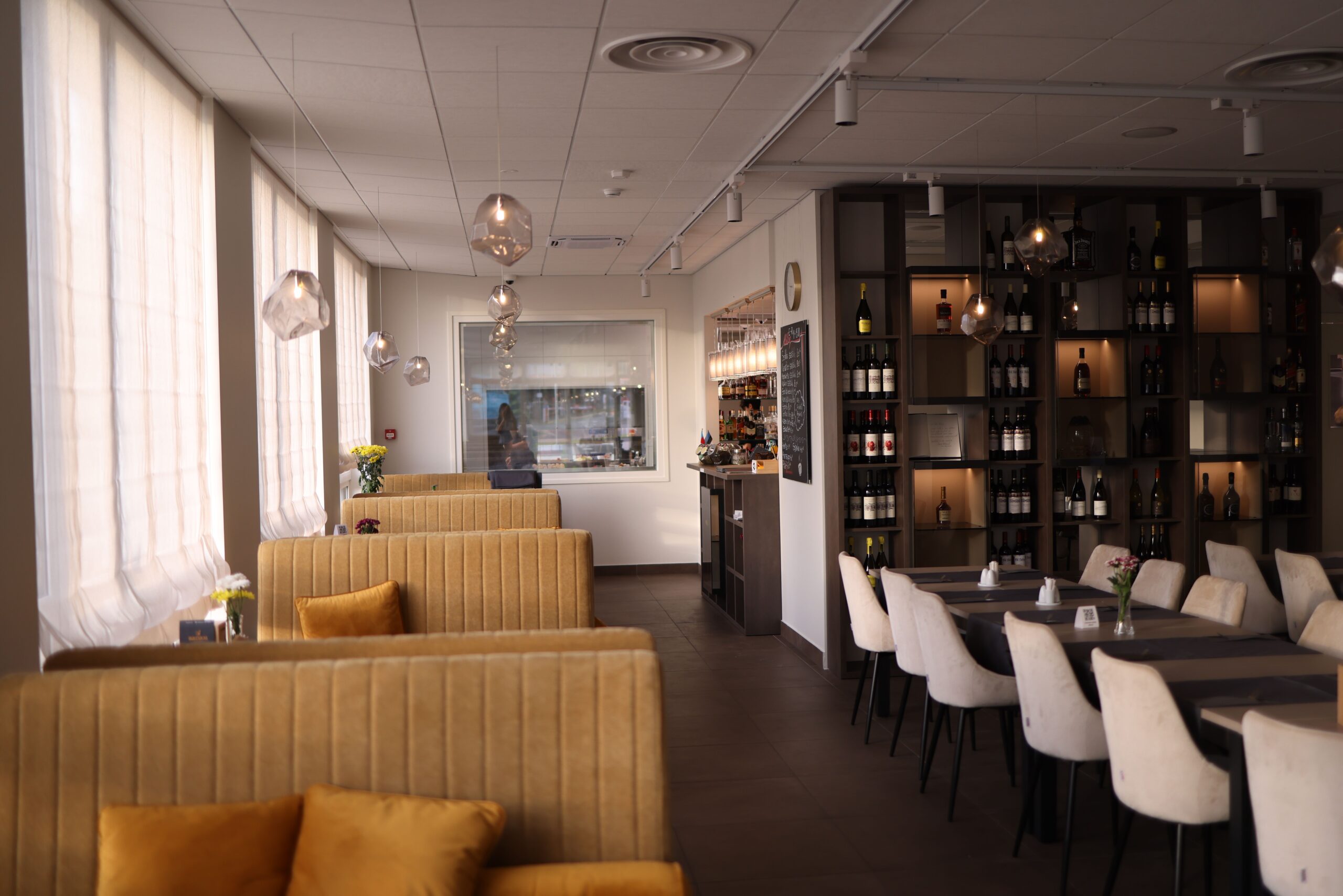 Modern restaurant interior design featuring cozy booth seating and elegant lighting.