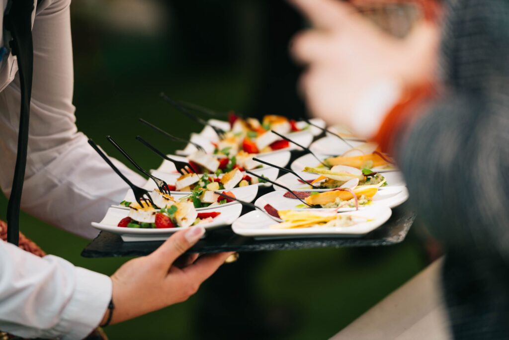 Elegant catering presentation with gourmet appetizers on a tray at a social event.